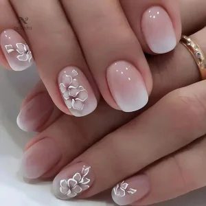Faux ongles dégradé rose nude avec fleurs 3D blanches
