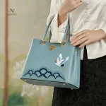 Sac à main femme bleu avec grue brodée et finitions dorées
